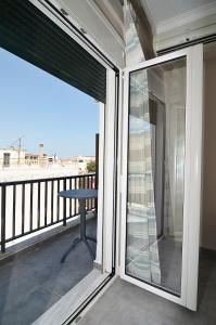 eleftheria's apartment في مدينة خانيا: شرفة مع أبواب زجاجية منزلقة وطاولة
