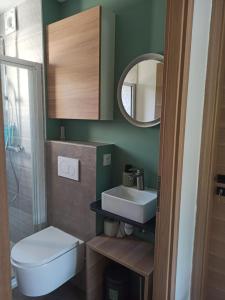 W łazience znajduje się umywalka, toaleta i lustro. w obiekcie Chambre au coeur des vignes w mieście Myans