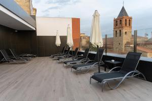 une rangée de chaises et de parasols blancs sur un toit dans l'établissement Hotel Aldama, à Mérida