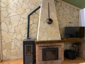 Zimmer mit einem Kamin, einem TV und einem TV. in der Unterkunft Casa Rural Coripe in Coripe