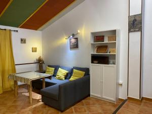 ein Wohnzimmer mit einem blauen Sofa und einem Tisch in der Unterkunft Casa Rural Coripe in Coripe