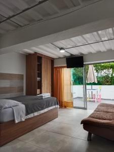 a bedroom with a large bed and a television at Bird House - Apartament in Jardin