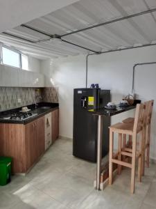 a kitchen with a black refrigerator and a table at Bird House - Apartament in Jardin