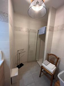 a bathroom with a shower and a chair and a sink at Résidence de la Brasserie in Saint-Valery-sur-Somme +4 photos