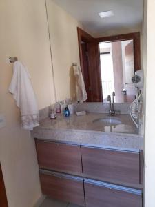 y baño con lavabo y espejo. en Apartamento Quartier no Parque Aldeia das Aguas, en Barra do Piraí