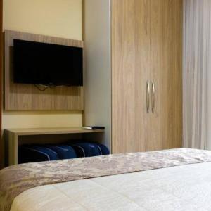 1 dormitorio con 1 cama y TV de pantalla plana en Apartamento Quartier no Parque Aldeia das Aguas, en Barra do Piraí
