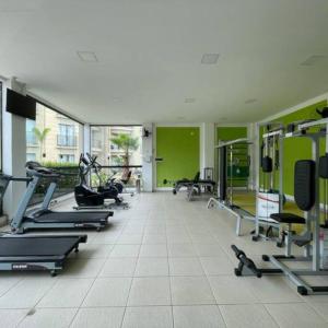 un gimnasio con una fila de cintas de correr y máquinas en Apartamento Quartier no Parque Aldeia das Aguas, en Barra do Piraí