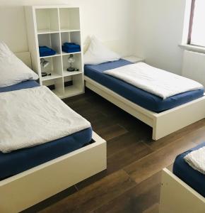 twee bedden in een kamer met houten vloeren bij HOSTEL 66 Bremerhaven Geestland in Imsum