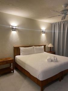 ein Schlafzimmer mit einem Bett mit zwei ausgestopften Tieren darauf in der Unterkunft Hotel Villas Ema in Zihuatanejo