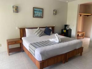 - une chambre dotée d'un grand lit avec un oiseau blanc dans l'établissement Hotel Villas Ema, à Zihuatanejo