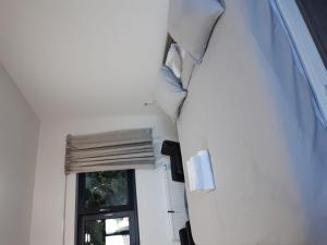 Schlafzimmer mit einem Bett und einem Fenster in der Unterkunft Résidence la floraison in Brüssel