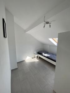 ein weißes Zimmer mit einem Bett und einem Fenster in der Unterkunft Ferien-& Monteurwohnung in Übach-Palenberg