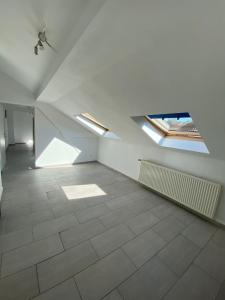 Cette chambre blanche vide dispose de lucarnes et de carrelage. dans l'établissement Ferien-& Monteurwohnung, à Übach-Palenberg