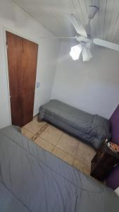 1 dormitorio con 1 cama y ventilador de techo en Hospedaje "LUZ" en Olavarría