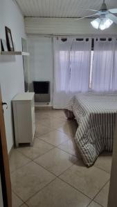 1 dormitorio con 1 cama y TV en Hospedaje "LUZ" en Olavarría