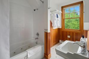 Hotel Mountain Brook في Tannersville: حمام مع حوض ومغسلة