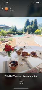 una foto di un tavolo con sopra del cibo di Villa Belvedere Versilia - Villa con tre camere, cucina, sala, giardino con piscina e vista - 7 posti letto a Camaiore