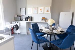 comedor con mesa y sillas azules en 2 Bed Apartment by AV Stays Short Lets & Serviced Accommodation Sittingbourne Kent, en Kent