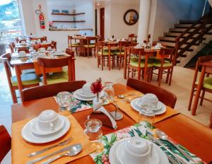 a dining room with wooden tables and chairs at Pousada João Fernandes in Búzios