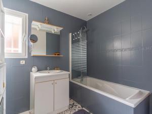 a blue bathroom with a sink and a bath tub at Maison à Mimizan avec piscine, 4 personnes, proche lac, activités à proximité - FR-1-50-102 in Mimizan +4 photos