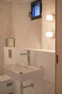 a bathroom with a white sink and a window at La Ferme de Brouage - GIte #3 in La-Gripperie-Saint-Symphorien