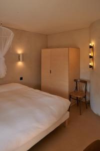 a bedroom with a bed and a chair and a cabinet at La Ferme de Brouage - GIte #3 in La-Gripperie-Saint-Symphorien +31 photos