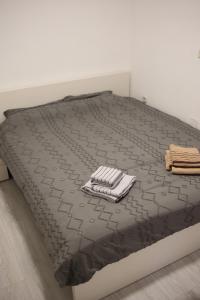 a bed with a black comforter on top of it at Cavleski apartment in Prilep