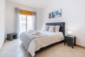 een slaapkamer met een groot bed en een raam bij Sea-Front near Vilamoura - with AC, WiFi, Netflix in Quarteira