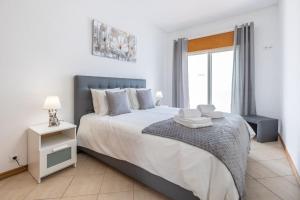 um quarto com uma cama grande e uma janela em Sea-Front near Vilamoura - with AC, WiFi, Netflix em Quarteira