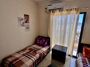 a small bedroom with a bed and a window at DeadSea Accommodation with AC in Sowayma
