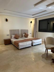 sypialnia z 2 łóżkami i krzesłem w obiekcie Villa Novia w Marakeszu