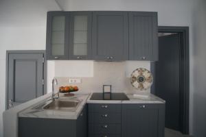 una cocina con armarios negros y fregadero en Krotiri View Paros, en Krotiri