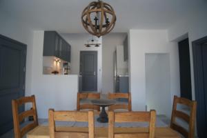 een eetkamer met een tafel en stoelen en een kroonluchter bij Krotiri View Paros in Krotiri