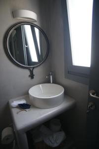 y baño con lavabo blanco y espejo. en Krotiri View Paros, en Krotiri