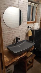 ein Bad mit einem schwarzen Waschbecken und einem Spiegel in der Unterkunft Kuća za najam - IMANJE LUNA BAZEN JACUZZI in Sveti Ivan Žabno