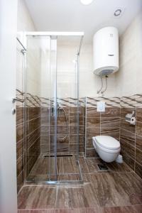 uma casa de banho com um chuveiro e um WC. em Apartments Blanco em Budva