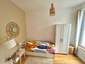 a bedroom with a bed and a table and a lamp at Appartement entier en plein coeur du centre ville in Compiègne