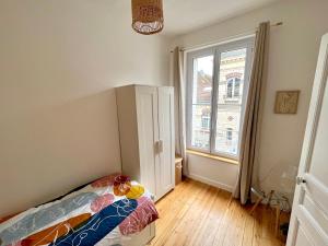 - une chambre avec un lit et une grande fenêtre dans l'établissement Appartement entier en plein coeur du centre ville, à Compiègne