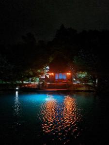 a house with lights on the water at night at Jajce,Plivsko jezero in Jajce