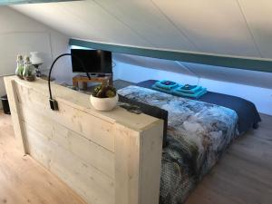 ein Schlafzimmer mit einem Bett und einem TV darüber in der Unterkunft Altynghe in Beilen