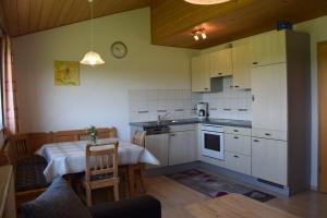 a kitchen with white cabinets and a table and a dining room at Bauernhof Dieing in Isny im Allgäu