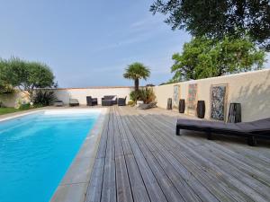 einen Pool auf einer Holzterrasse neben einem Haus in der Unterkunft Maison Angoulins, 6 pièces, 6 personnes - FR-1-706-13 in Angoulins-sur-Mer