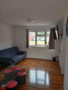 a living room with a couch and a table at 3 bedrtoom comfortable house in Houghton Regis