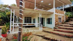 eine Veranda eines Hauses mit einer Palme in der Unterkunft FINCA VILLA MAGALY en medio de la Naturaleza in Melgar