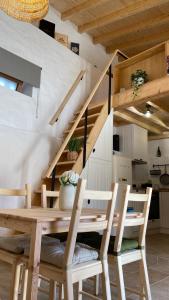 una mesa de madera y sillas en una habitación con escalera en Casa de Alcaria en Alcaria