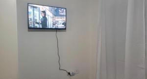 Elle comprend une télévision à écran plat sur un mur blanc. dans l'établissement Departamento Mis Nonos 2, à Mendoza