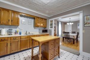 a kitchen with wooden cabinets and a dining room at Maine Vacation Rental about 1 Mi to Auburn Riverwalk! in Auburn