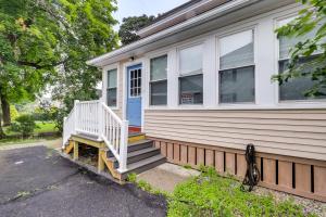 una casa con un porche blanco y una puerta azul en Maine Vacation Rental about 1 Mi to Auburn Riverwalk! en Auburn