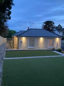 una casa con luces en la parte delantera de un patio en Gwaelodygarth Lodge en Merthyr Tydfil
