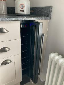 een zwarte koelkast onder een aanrecht in een keuken bij Gwaelodygarth Lodge in Merthyr Tydfil